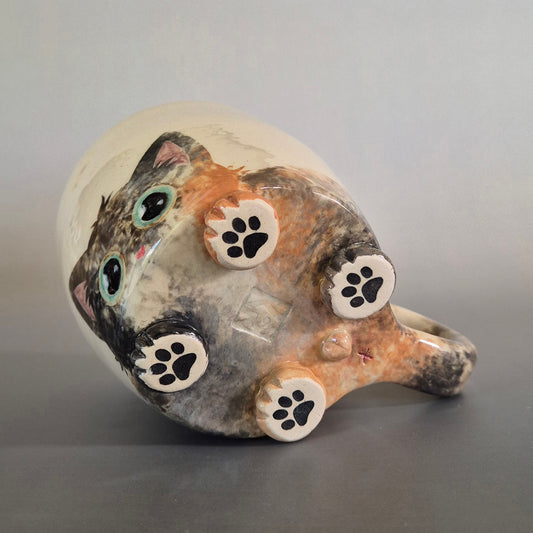 Ceramic mug with cat design on a gray background