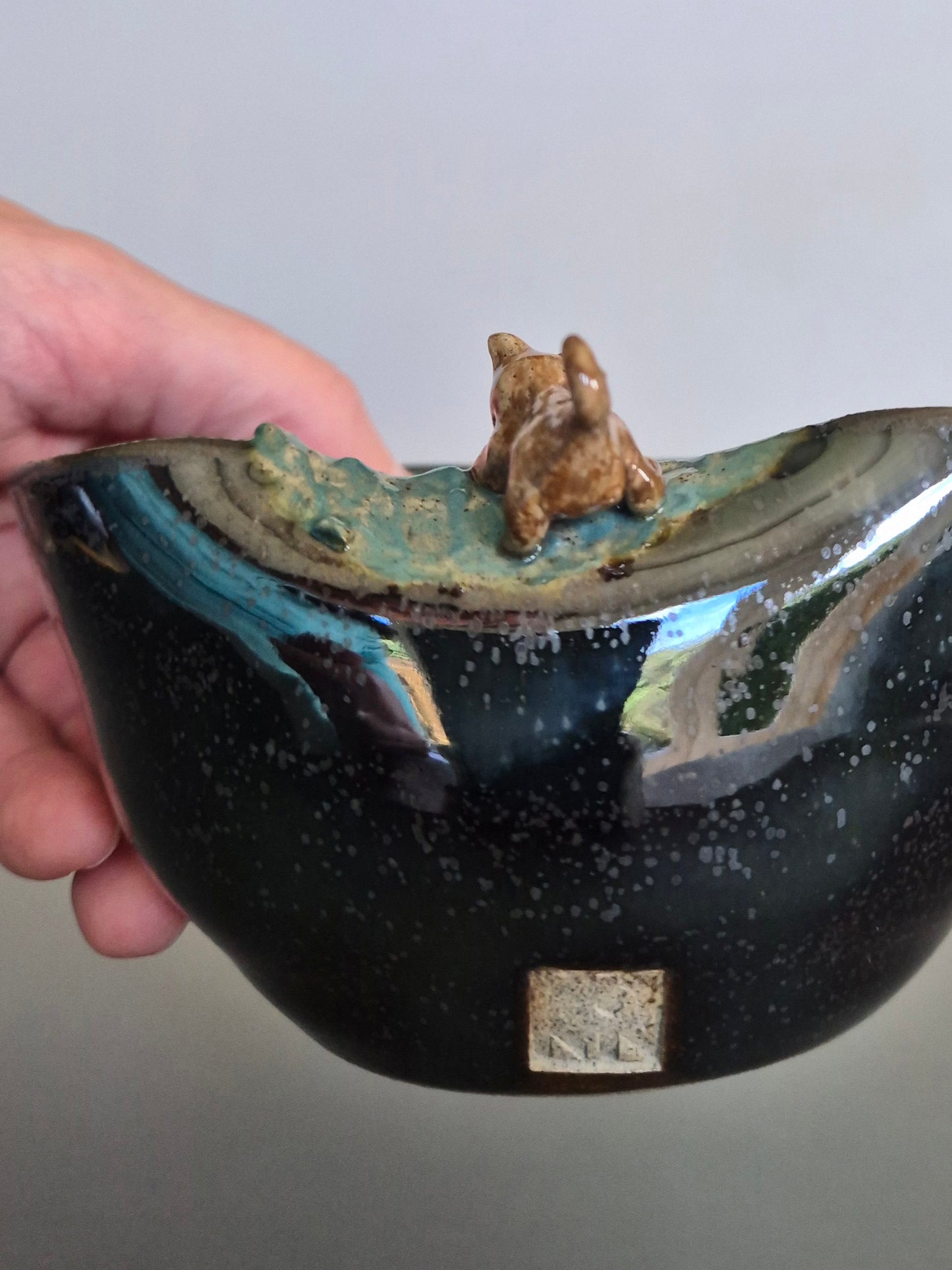 Ceramic bowl with a small figurine of a dog on a gray background