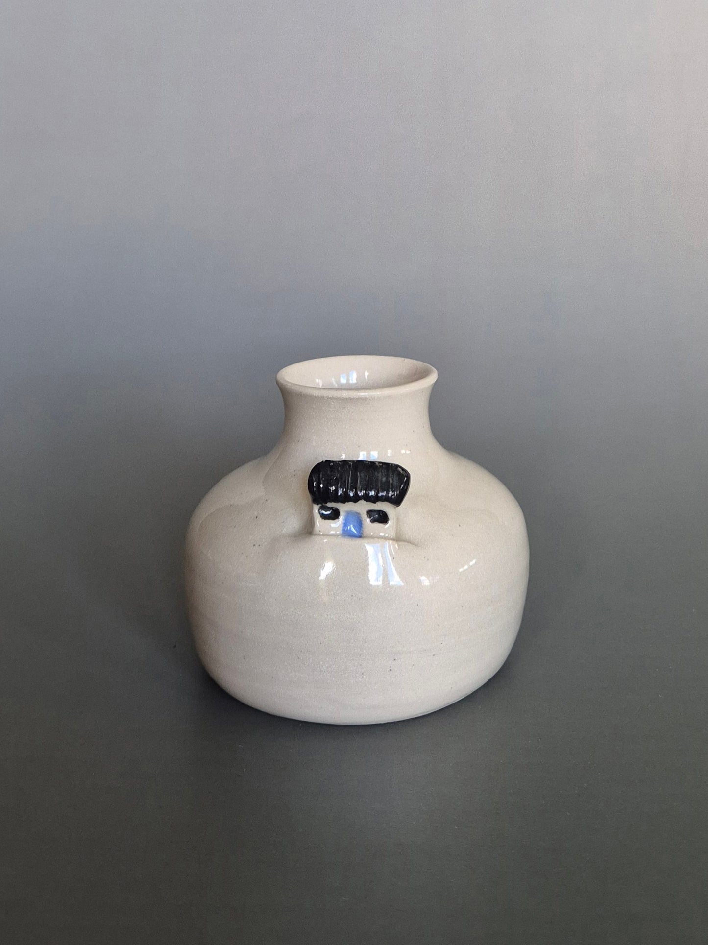 Small white ceramic bottle or bud vase. On a plain background