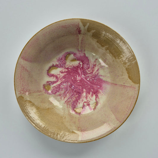 Ceramic bowl with marbled pink and white design on a gray background