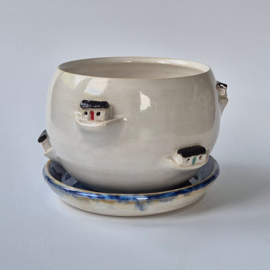 Ceramic pot with boothy house designs on a white background