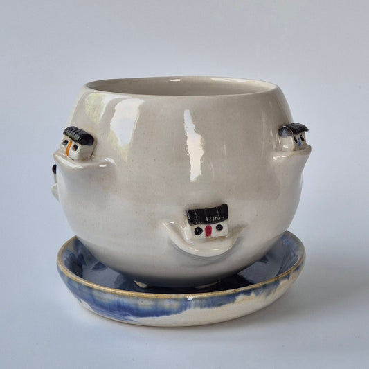 Ceramic pot decorated with little houses on a white background