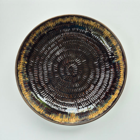 Ceramic plate with concentric circle pattern on a white background