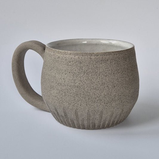 Speckled brown ceramic mug on a light gray background