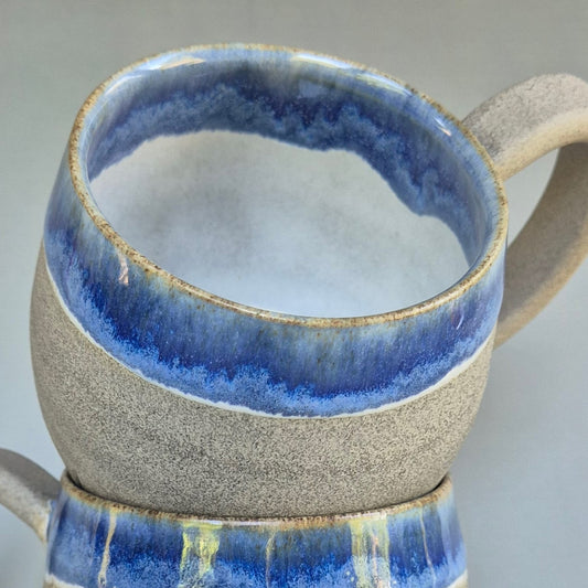 Ceramic mug with blue interior and exterior on a gray background
