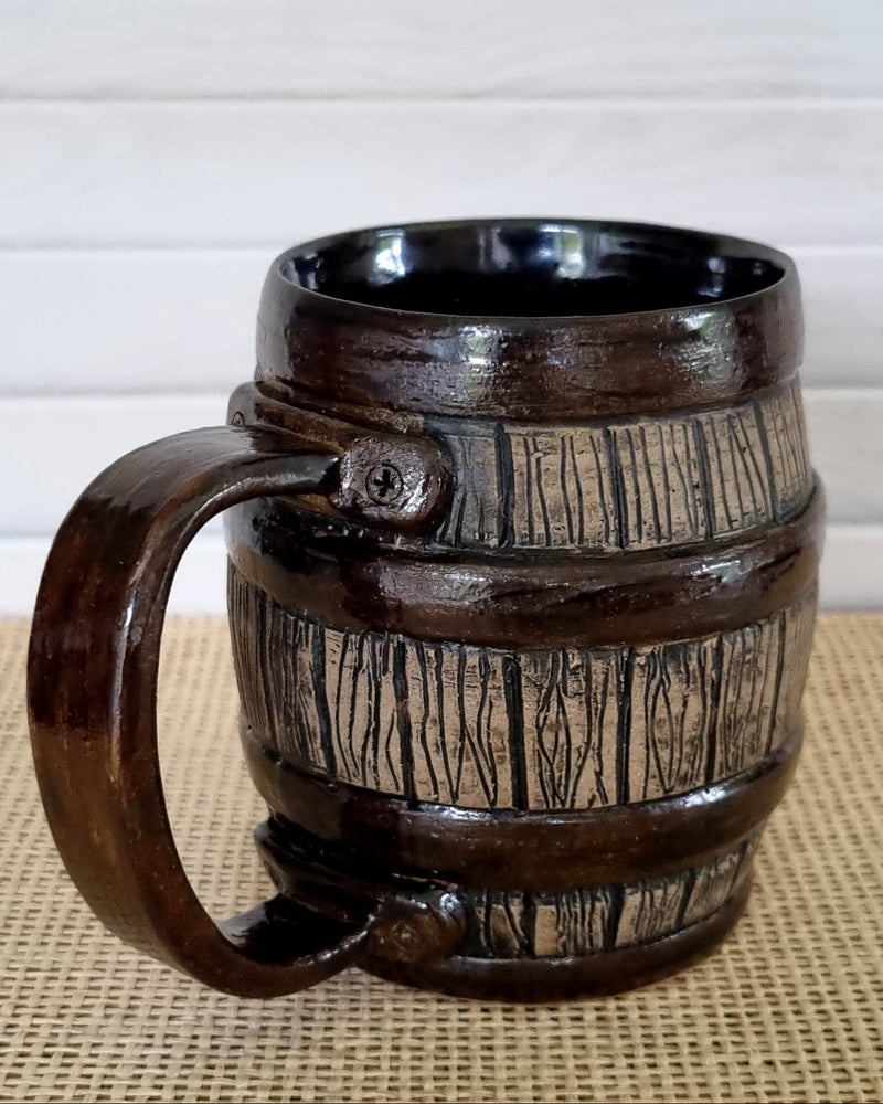 Ceramic wooden effect mug with barrel design on a textured surface
