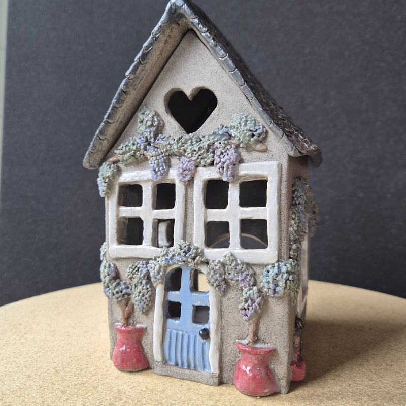 Decorative miniature house with colorful details on a textured surface