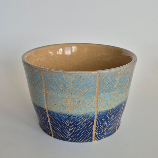Ceramic pot with blue and beige gradient on a white background