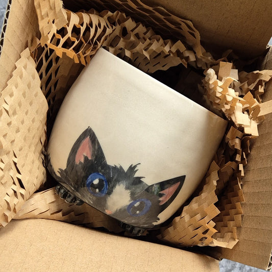 Ceramic mug with a cat design in a box with brown tissue paper