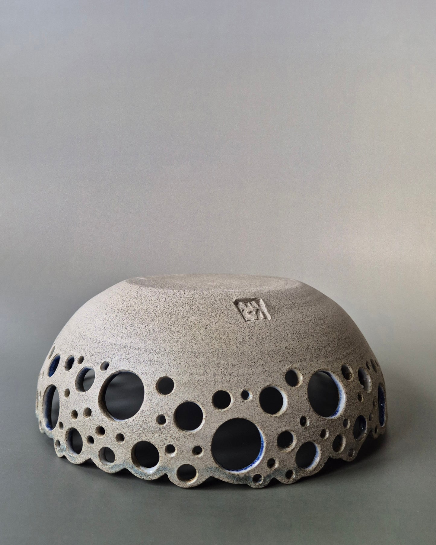 Ceramic bowl with bubble-like texture on a gray background