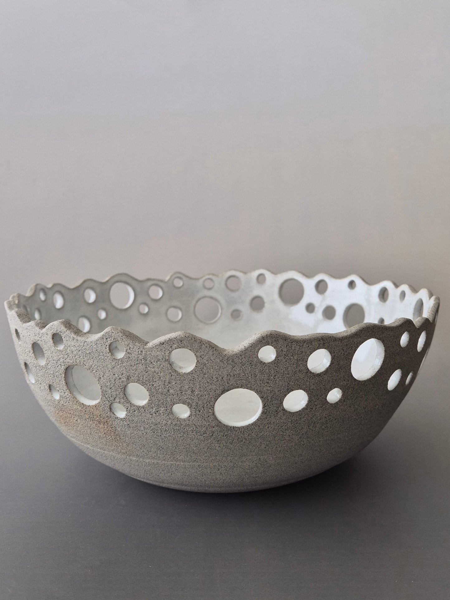 Ceramic bowl with decorative edge on a gray background