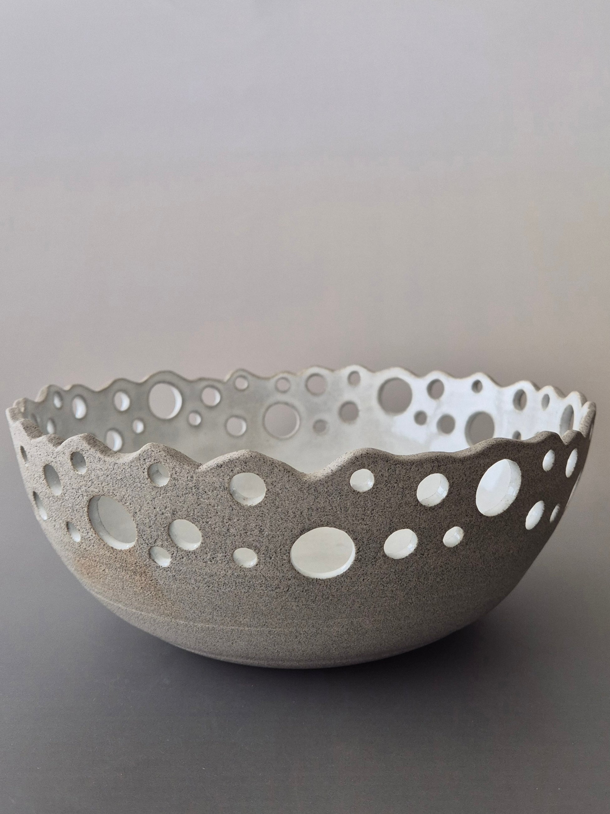 Ceramic bowl with decorative edge on a gray background