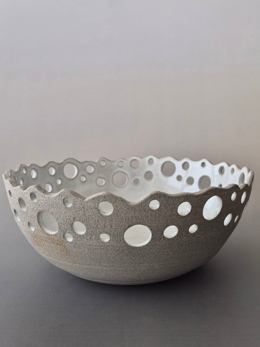Ceramic bowl with decorative edge on a gray background
