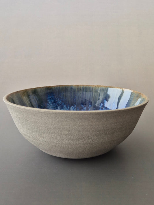 Ceramic bowl with blue interior on a gray background