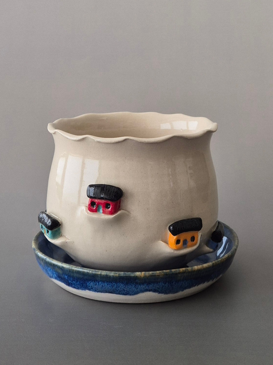 Ceramic pot with decorative elements on a gray background