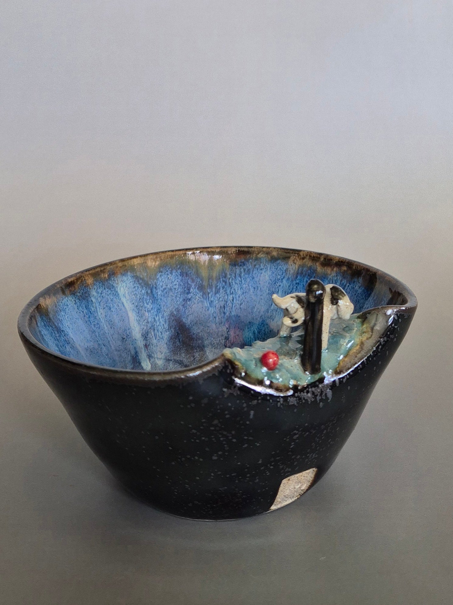 Ceramic bowl with small dog sculptural design on a gray background