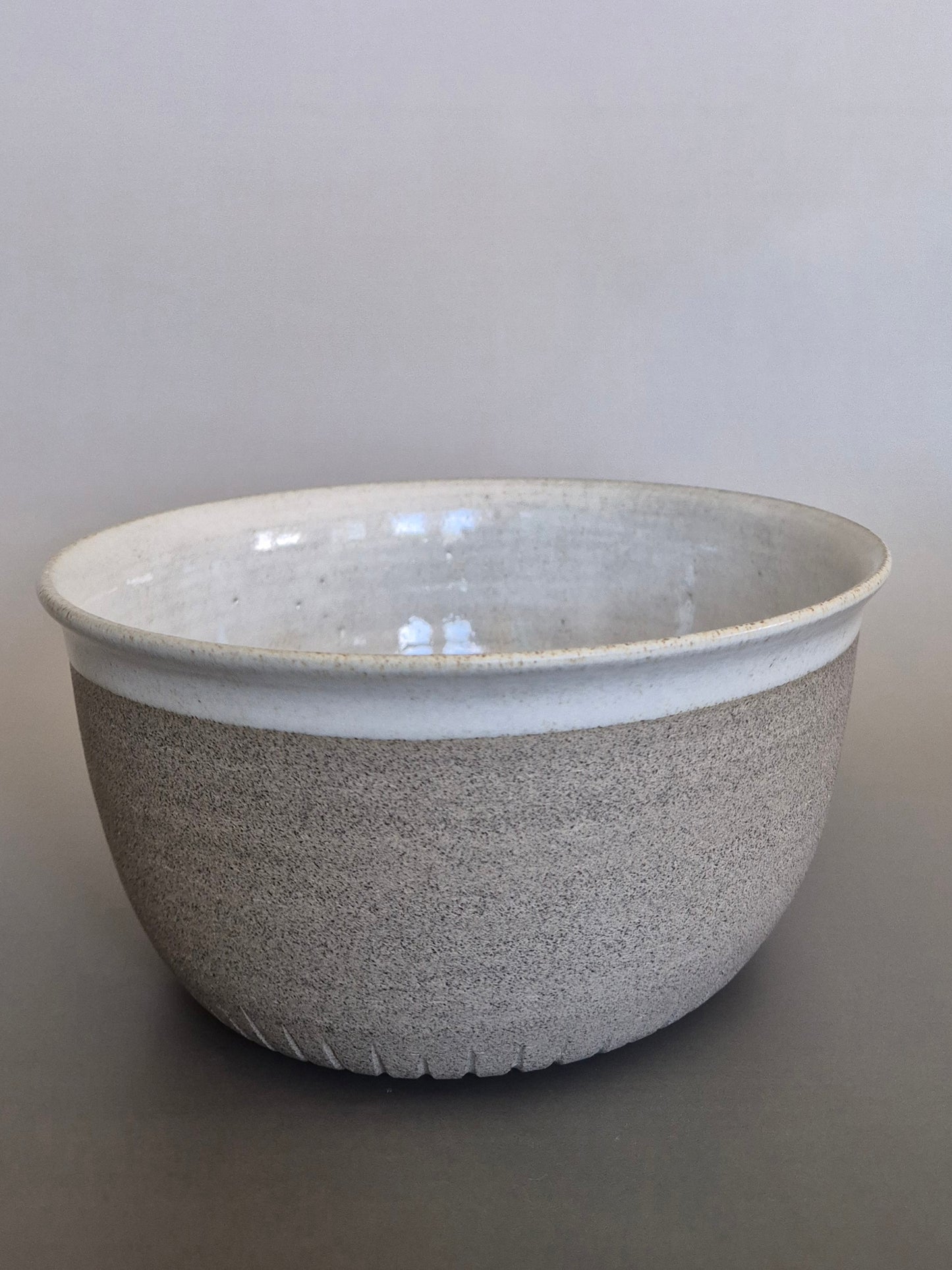 Speckled gray ceramic bowl on a plain background