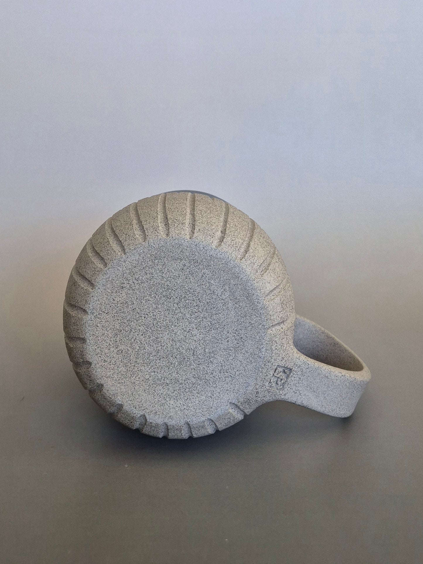 Base of a ceramic mug with textured surface on a plain background