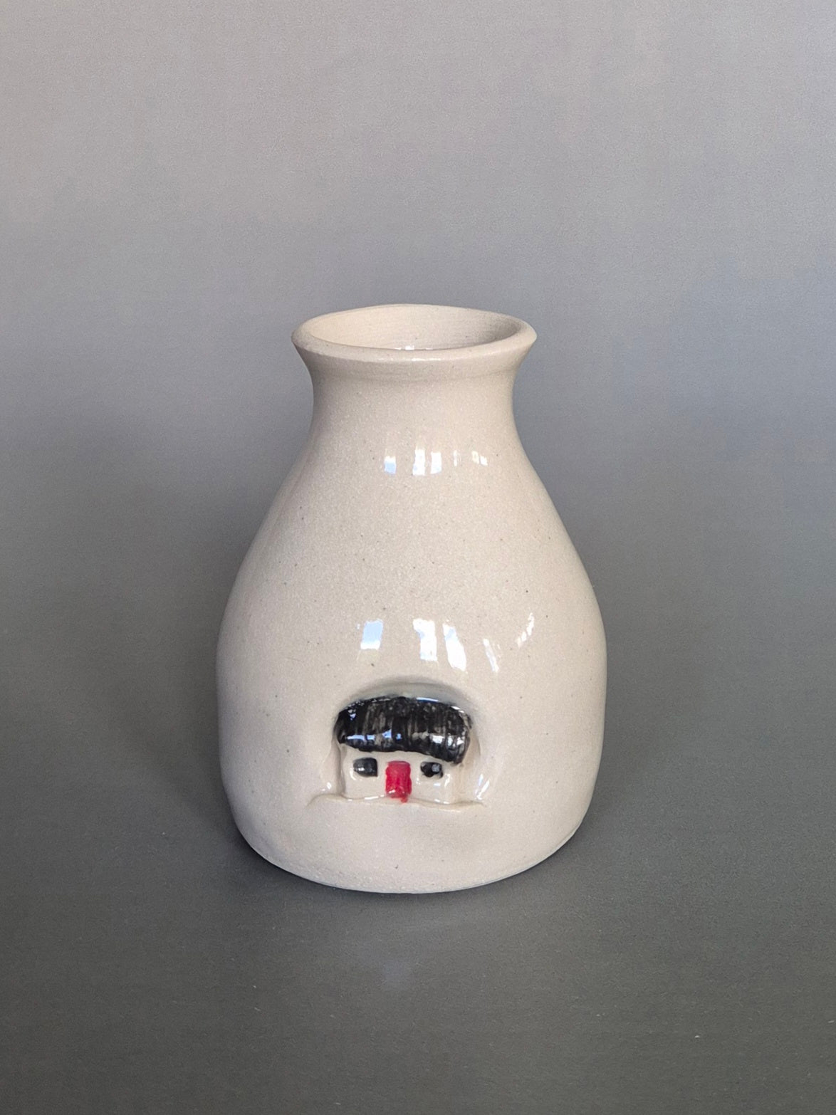 Small white ceramic bottle or bud vase. On a plain background