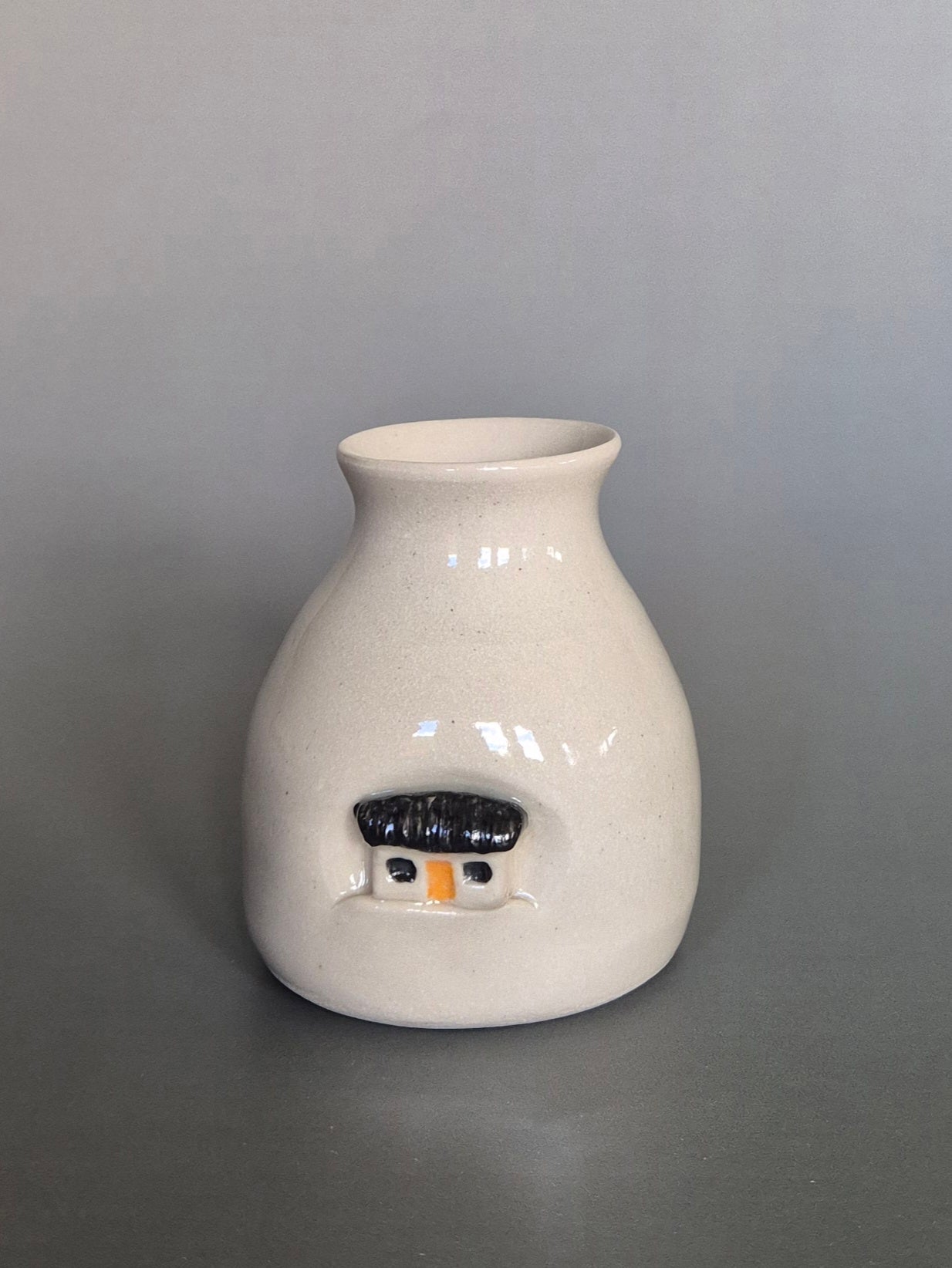 Small white ceramic bottle or bud vase. On a plain background
