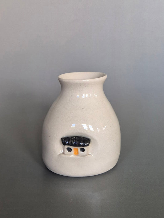 Small white ceramic bottle or bud vase. On a plain background