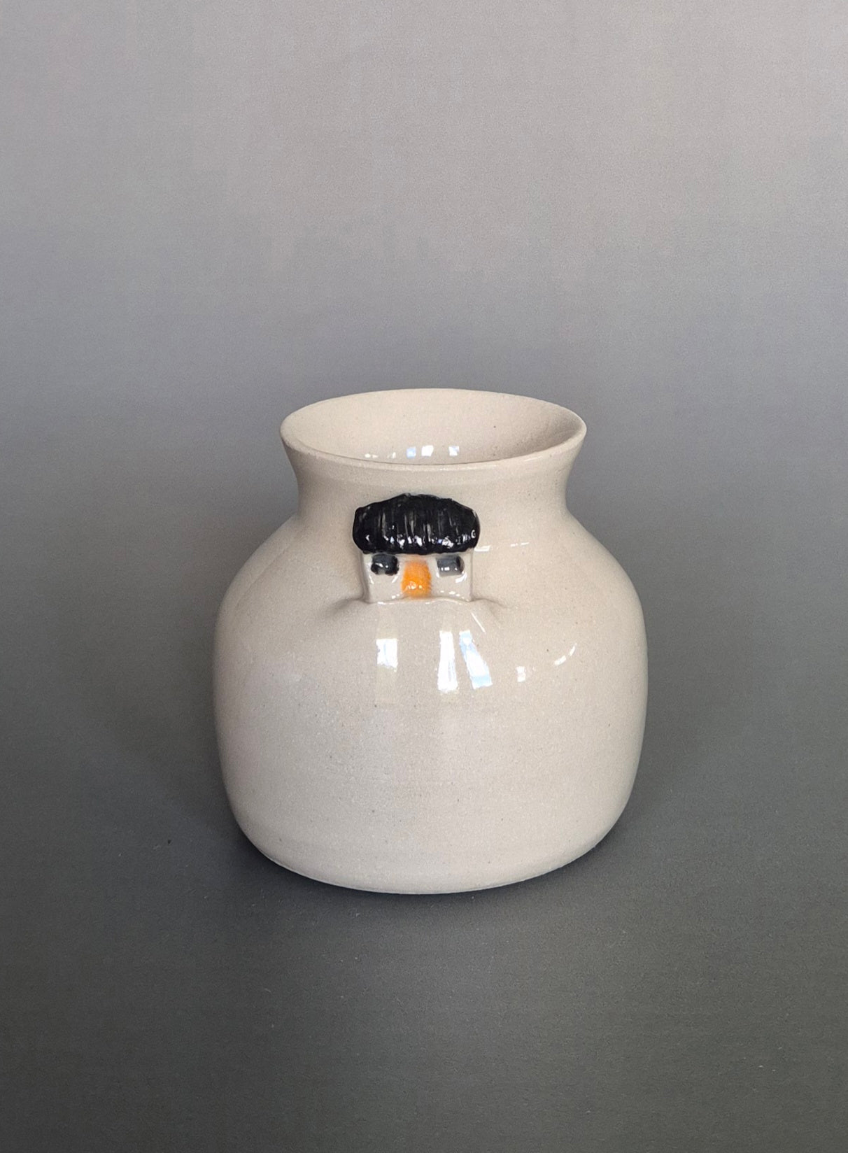 Small white ceramic bottle or bud vase. On a plain background