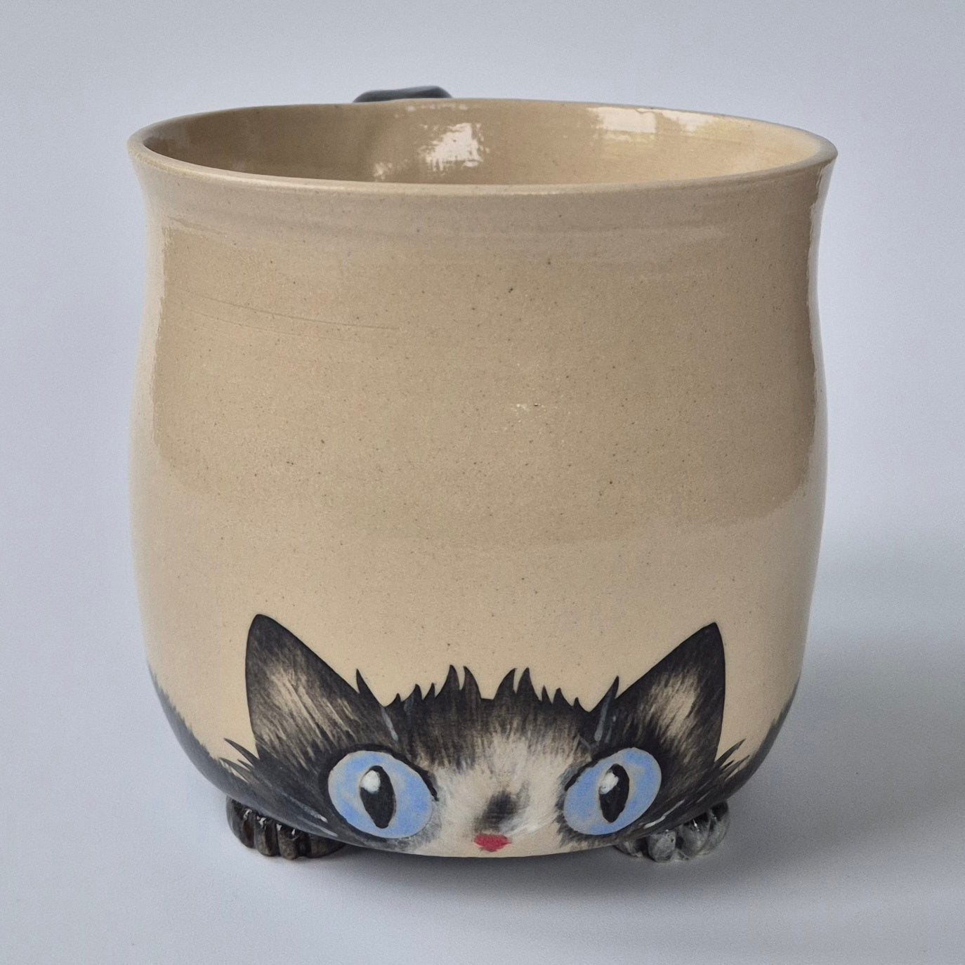 Ceramic mug with a cat illustration on a plain background