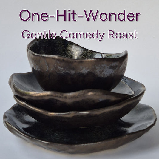 Set of three dark ceramic bowls on a light gray background with text 'One-Hit-Wonder Gentle Comedy Roast'.