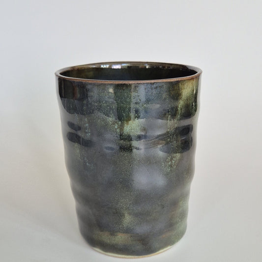 Dark green ceramic pencil pot. On a light background