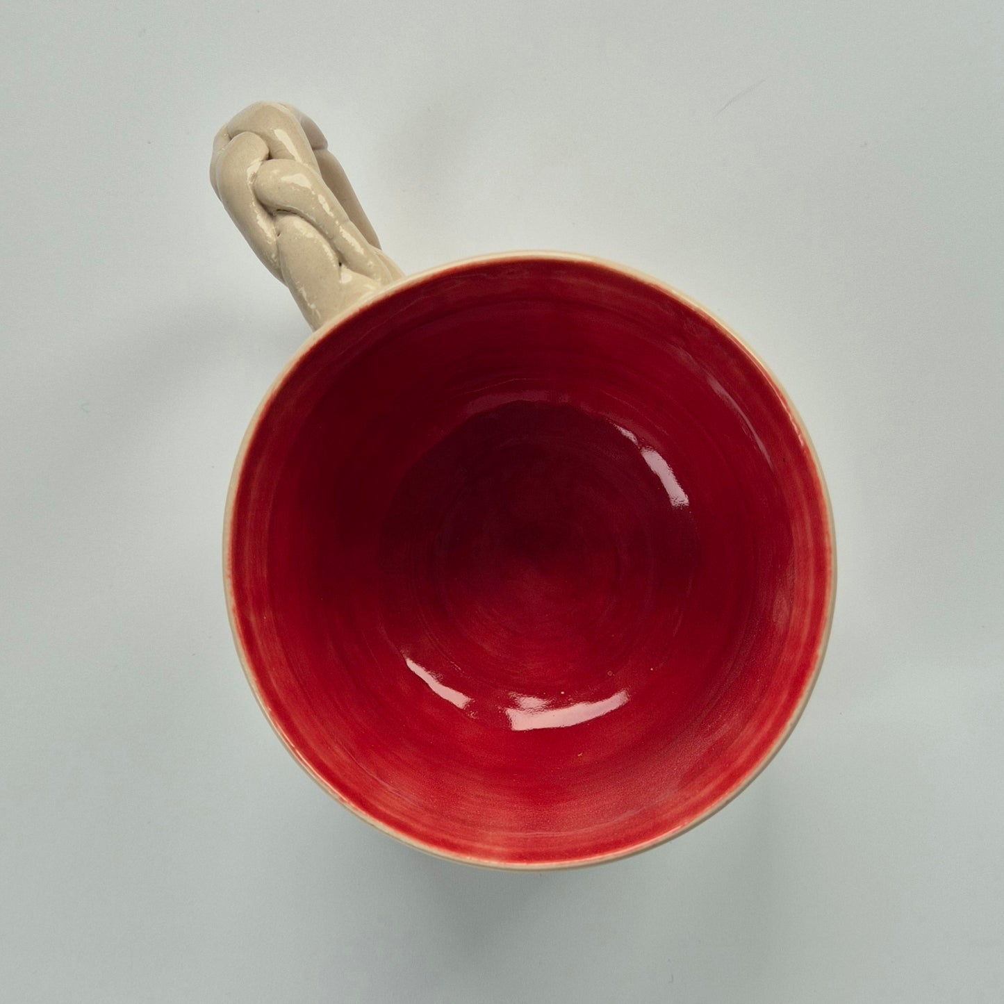 Ppink ceramic mug with a beige handle on a light gray background