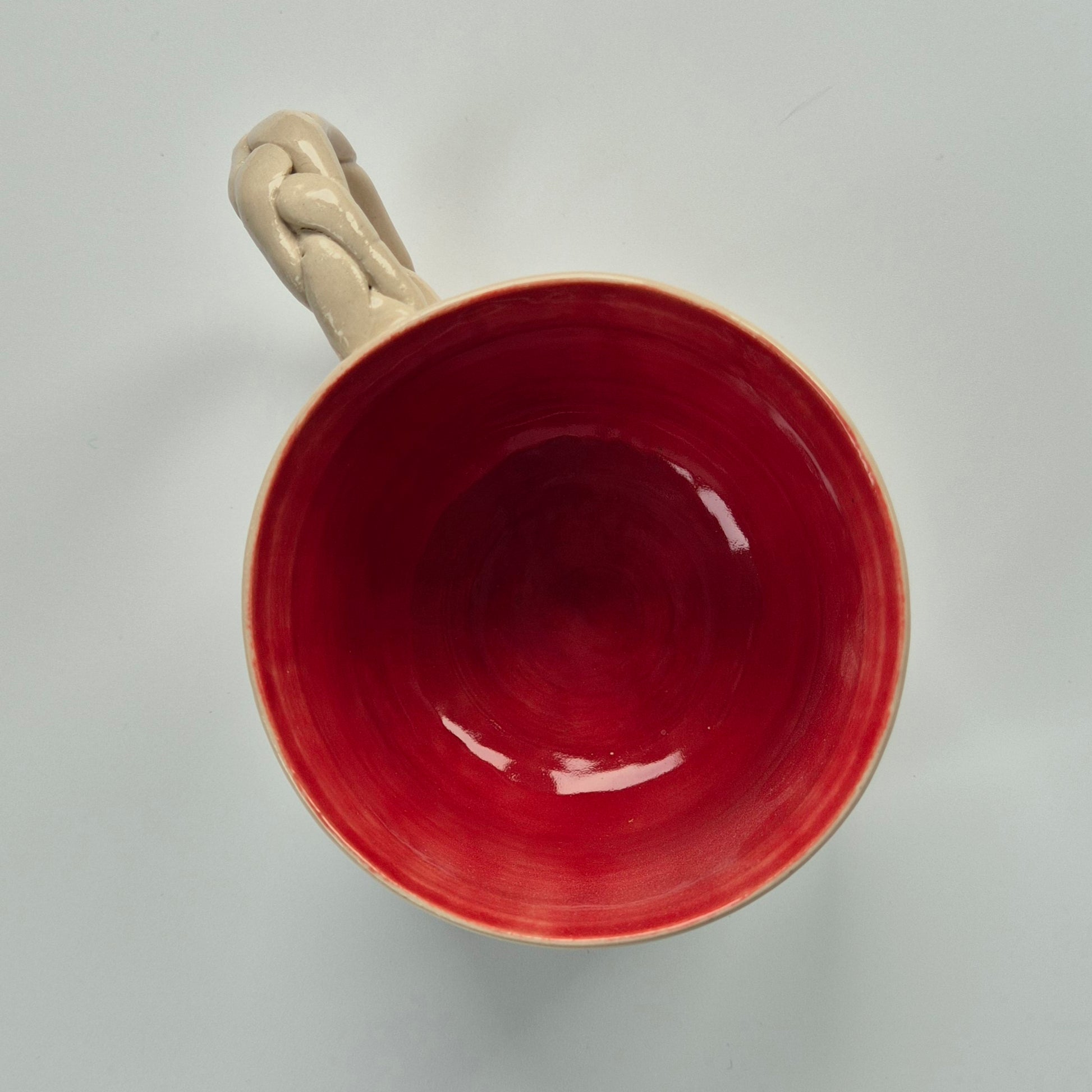 Ppink ceramic mug with a beige handle on a light gray background