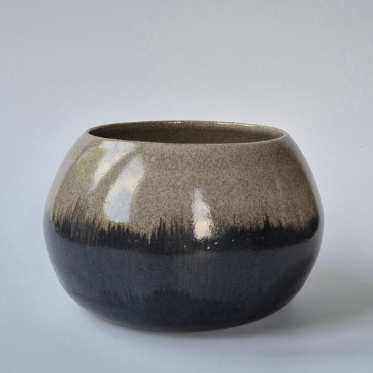 Glossy ceramic pot with gradient finish on a gray background