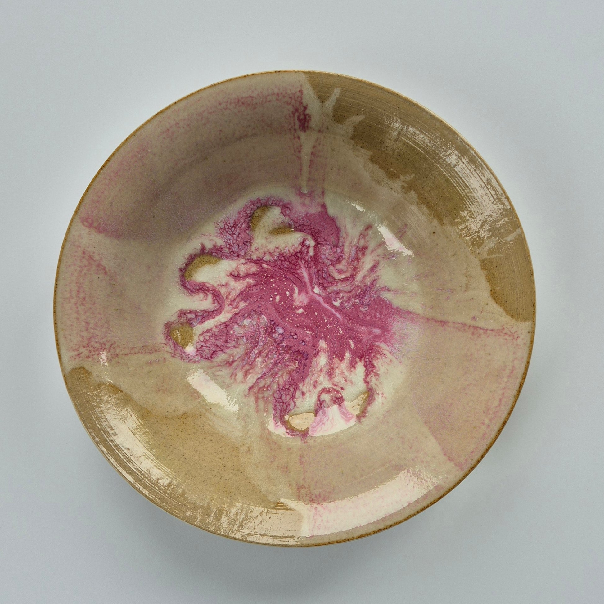 Ceramic bowl with marbled pink and white design on a gray background