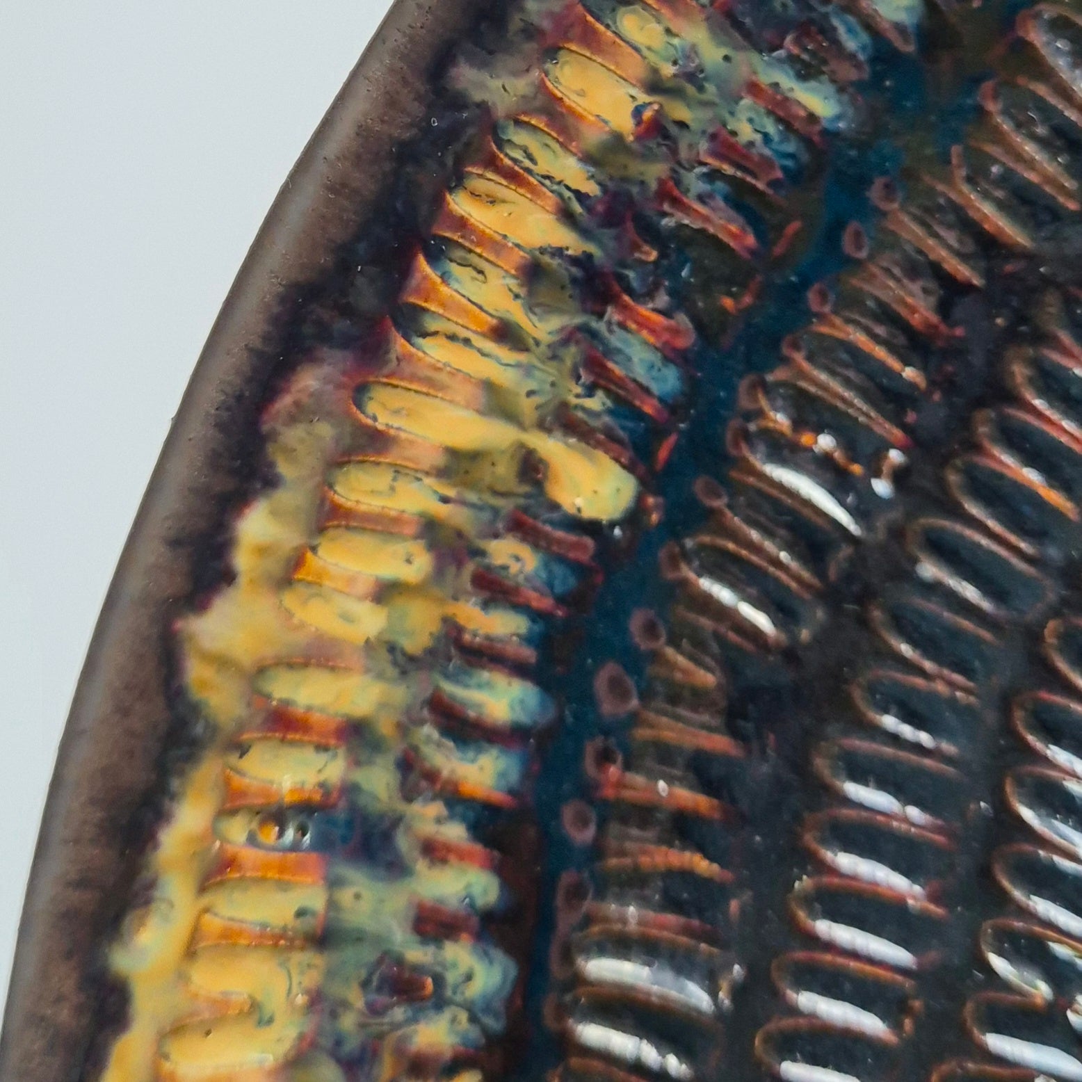 Close-up of a textured ceramic plate with a ribbed design on a white background