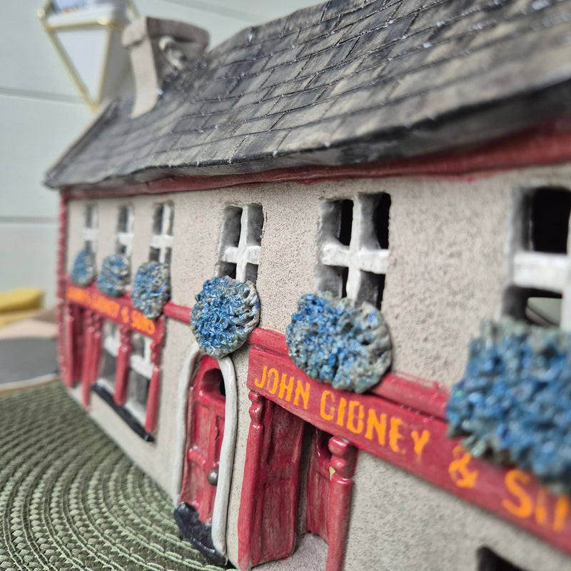 Close-up of a ceramic building with John Gibney & Sons signage and other decorative elements
