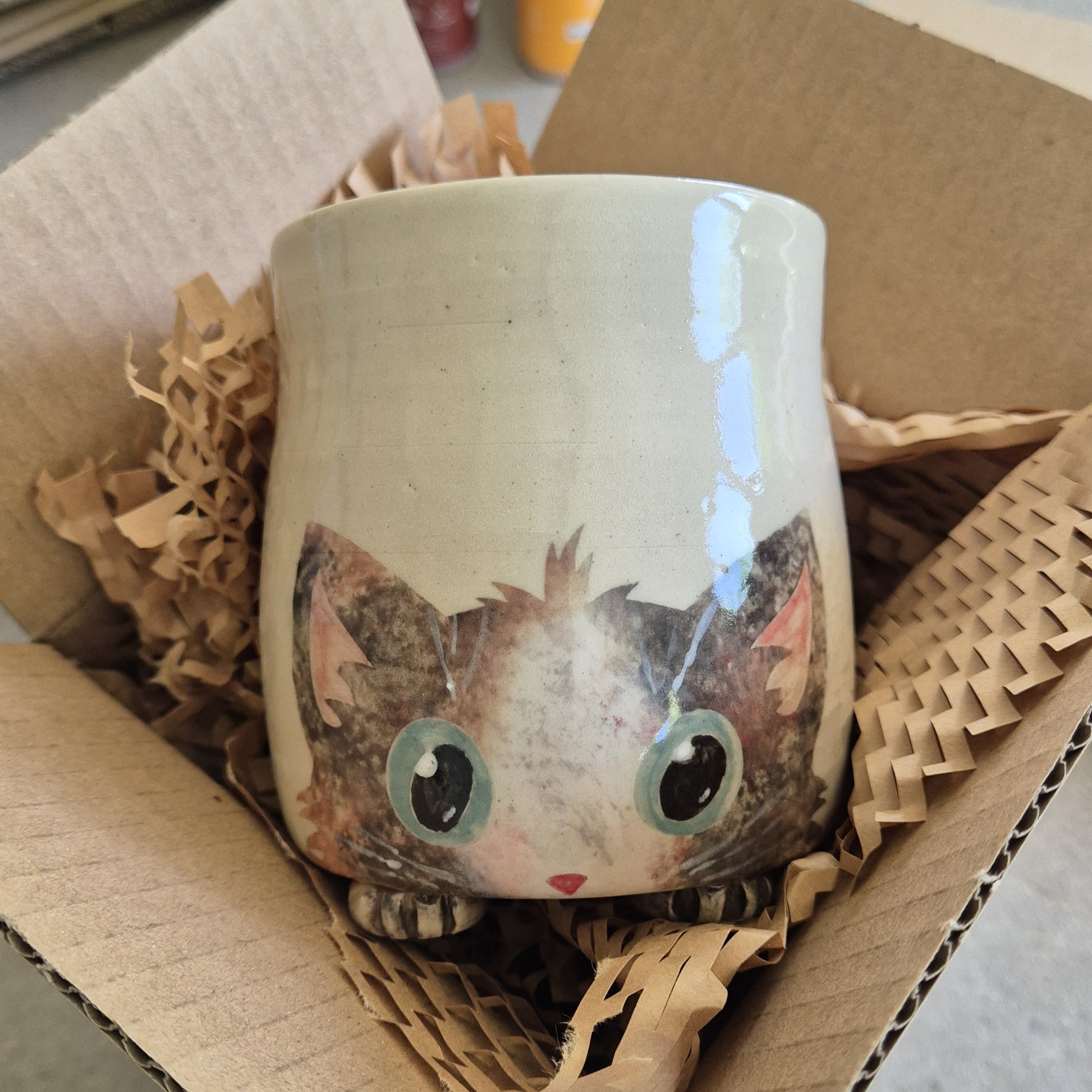 Hand-painted Cat Mug - Arlo - face up in a cardboard box