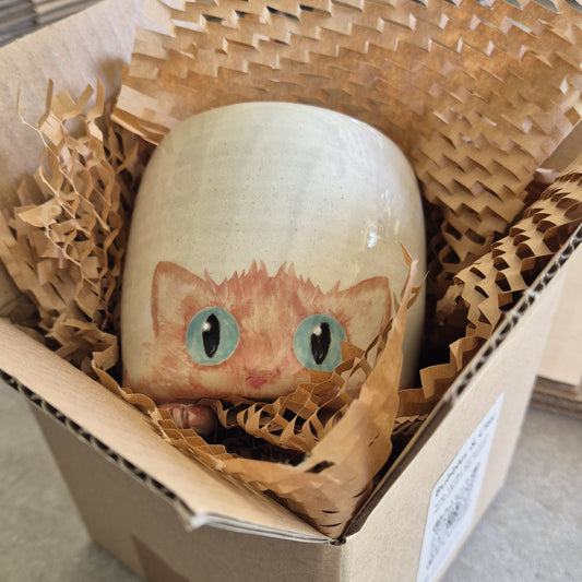Hand-painted Cat Mug - Amber - face up in a cardboard box