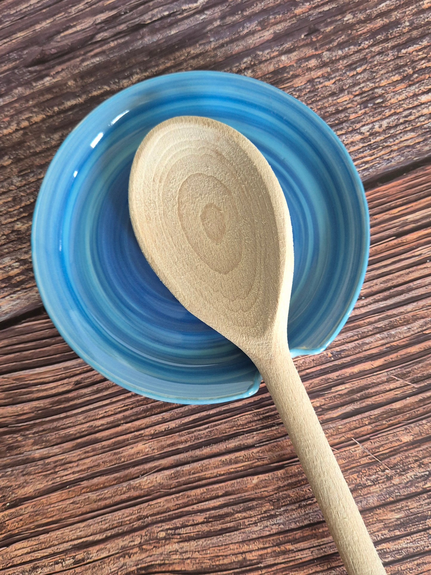 Wooden spoon on a blue ceramic dish with a wooden surface background