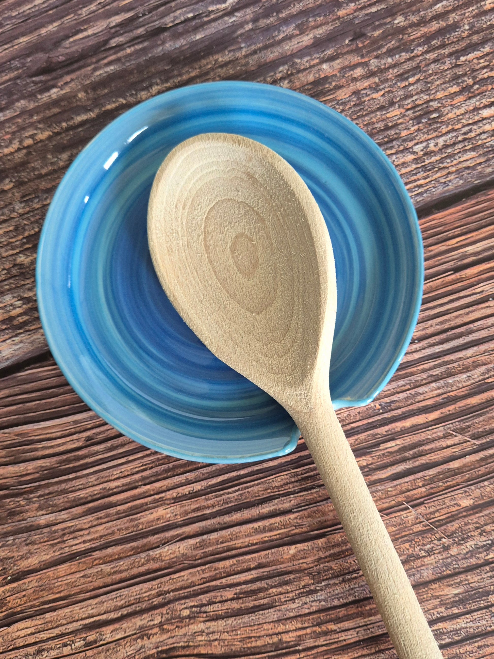 Wooden spoon on a blue ceramic dish with a wooden surface background